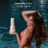 A woman in a red bikini smiles by a pool, holding a Fleshlight Girls: Riley Reid Utopia from Fleshlight. The text above her reads "Fleshlight Girls: Riley Reid Utopia.