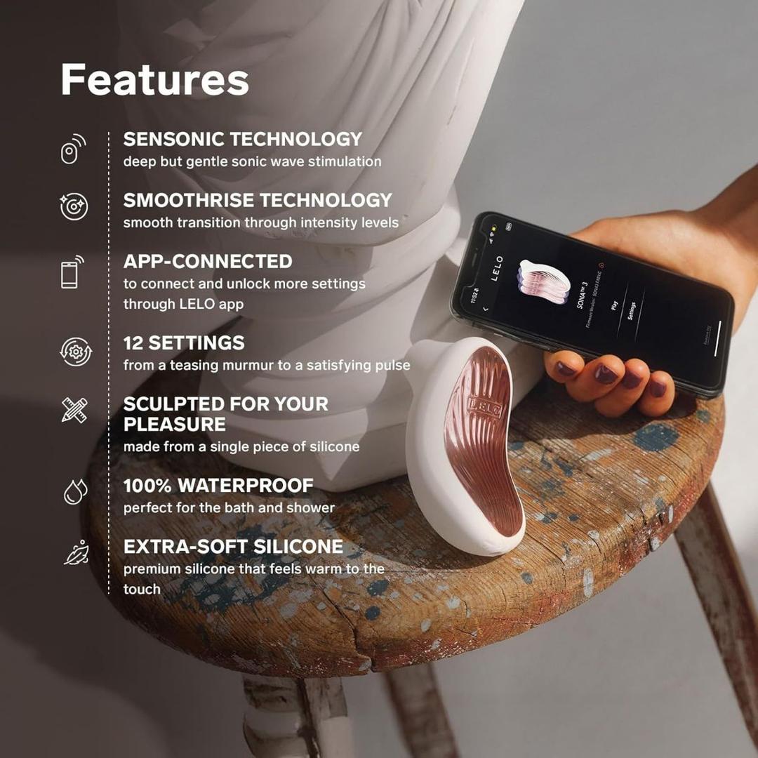 A hand holds a smartphone showing the LELO app beside the Lelo Sona 3 - Cream by LELO, a white and rose-gold silicone device on a wooden stool. Text highlights its waterproof design, soft silicone, app control, and multiple settings. A hand holds a smartphone showing the LELO app beside the Lelo Sona 3 - Cream by LELO, a white and rose-gold silicone device on a wooden stool. Text highlights its waterproof design, soft silicone, app control, and multiple settings.