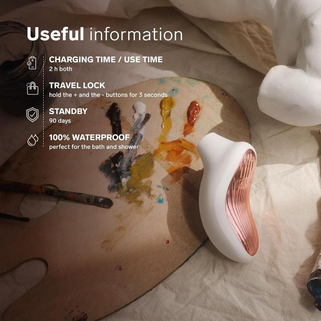 The LELO Sona 3 - Cream, a white and rose gold device, sits on a wooden artist’s palette with paint and brushes. The image highlights charging, travel lock, standby time, and waterproof features. The LELO Sona 3 - Cream, a white and rose gold device, sits on a wooden artist’s palette with paint and brushes. The image highlights charging, travel lock, standby time, and waterproof features.