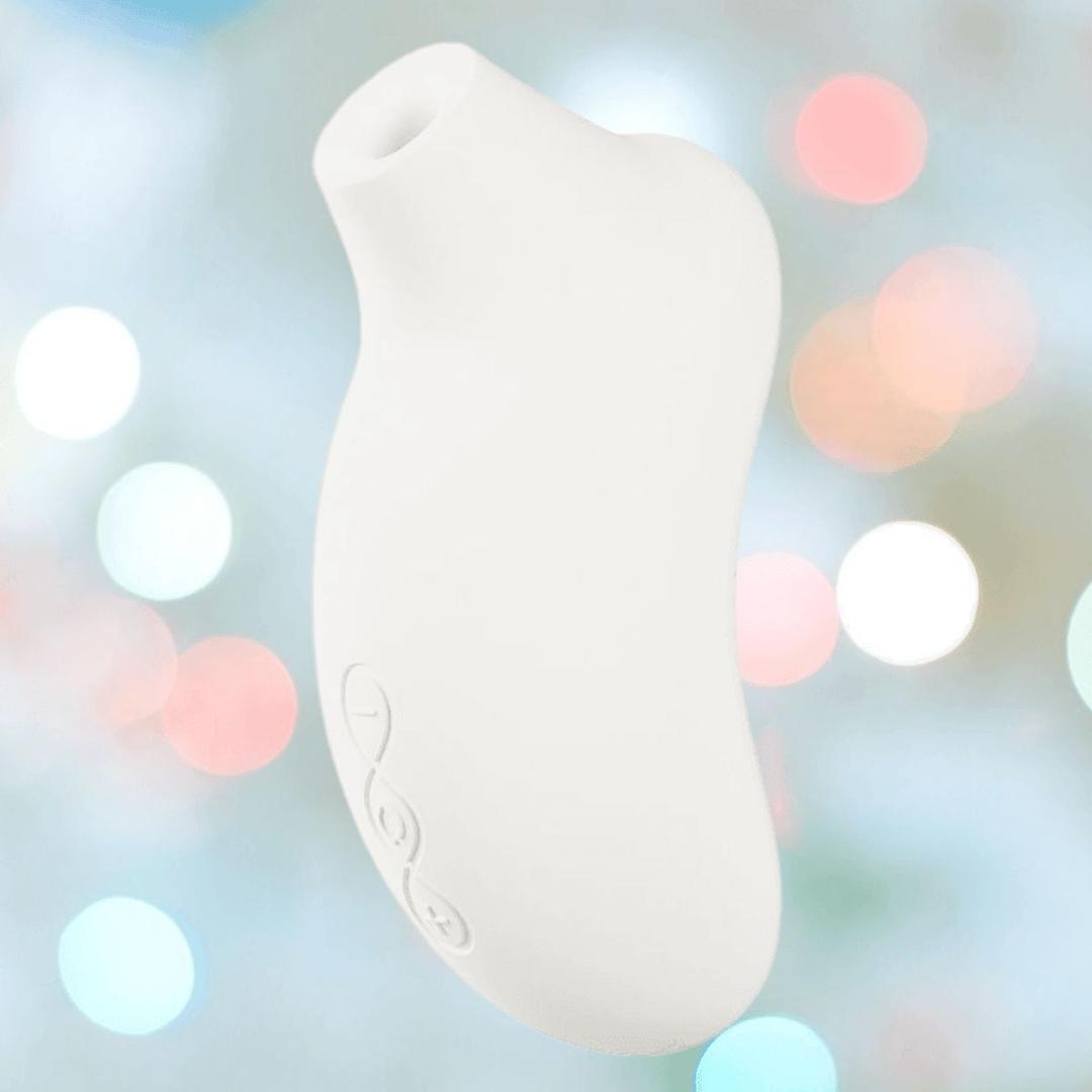 The LELO Sona 3 - Cream is a white, curved handheld device with a small round opening at one end, displayed against a soft backdrop of blurred pastel lights. The LELO Sona 3 - Cream is a white, curved handheld device with a small round opening at one end, displayed against a soft backdrop of blurred pastel lights.