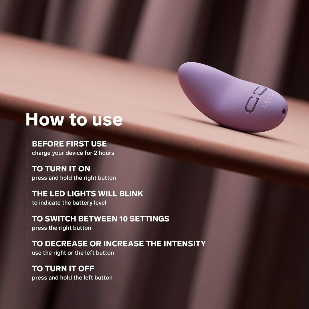 A LELO Lily 3 - Calm Lavender mini vibrator by LELO rests on a brown surface. White text describes how to charge, turn on/off, check LED lights, switch vibration modes, and adjust intensity. The background shows blurred diagonal lines.