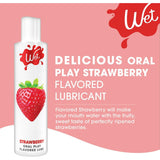 A bottle of Wet Delicious Oral Play Strawberry lubricant showcases a vibrant strawberry design, accompanied by the text "Strawberry Flavored Lubricant." The label highlights its sweet and fruity flavor, ideal for enhancing pleasure.