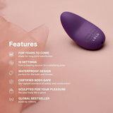 A LELO Lily 3 - Calm Lavender mini vibrator rests on soft pink fabric. Text beside it highlights durability, 10 vibration modes, waterproof design, body-safe materials, ergonomic shape, and worldwide popularity.