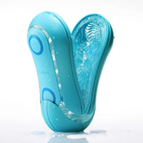 A Tenga Flip Orb Ocean Blue from Tenga is displayed open, showcasing its textured interior and spiral edges. It is positioned upright on a pristine white surface, with a few water droplets accentuating its waterproof capability.