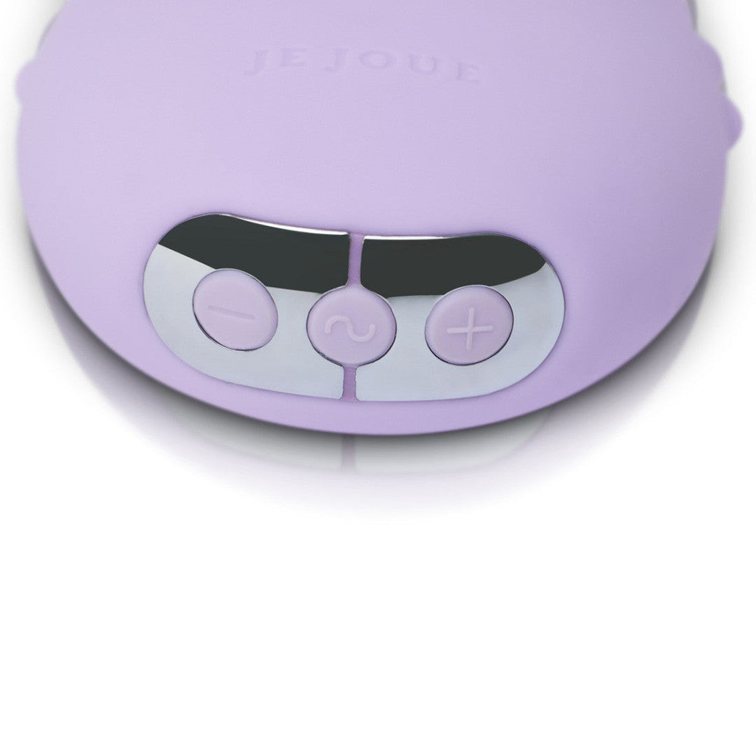 Close-up of the Je Joue Mimi Deux Pebble Vibrator in Lilac, an electronic device with a dual-texture design. It features a glossy control panel with three buttons: minus, wavy line, and plus. The low-frequency motor ensures a smooth experience, with the brand "Je Joue" embossed above the controls.