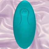 The Doc Johnson A-Play Thrust Adventurous Rechargeable Plug in teal, with an oval shape and subtle embossed design, rests on a soft, light purple satin fabric background.