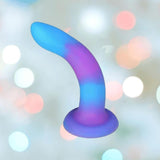 The BMS Addiction Rave Glow-in-the-Dark Bendable Vibrating Dong (Blue Purple, 8") features a curved shape and flared base, shown against a softly blurred pastel light background.