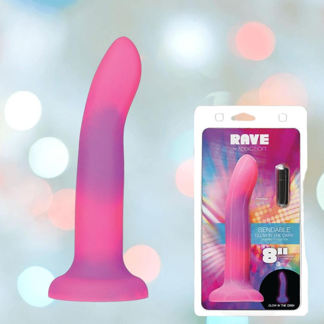 The Addiction Rave Glow-in-the-Dark Bendable Vibrating Dong by BMS is shown in pink and purple alongside its colorful packaging featuring product details, a strong suction base, and an 8-inch size.
