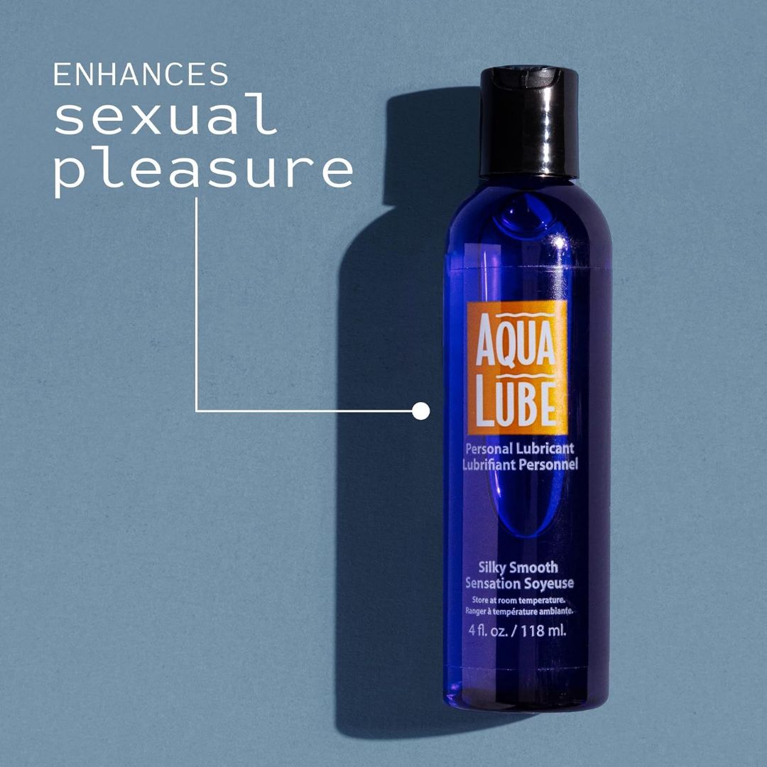 The image shows a bottle of Aqua Lube Water-Based Personal Lubricant by Kimono against a blue background. The dark blue bottle features an orange and white label. Text next to the bottle reads, "ENHANCES sexual pleasure." The 4 fl. oz./118 ml bottle is labeled "Silky Smooth Sensation.