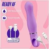 The Blush Novelties Aria Rechargeable Vibe Exciting AF-Indigo, a purple silicone G-spot vibrator with a curved design, is IPX7 waterproof, travel-friendly, and USB rechargeable. A USB charging cable is shown beside it on a pink background.