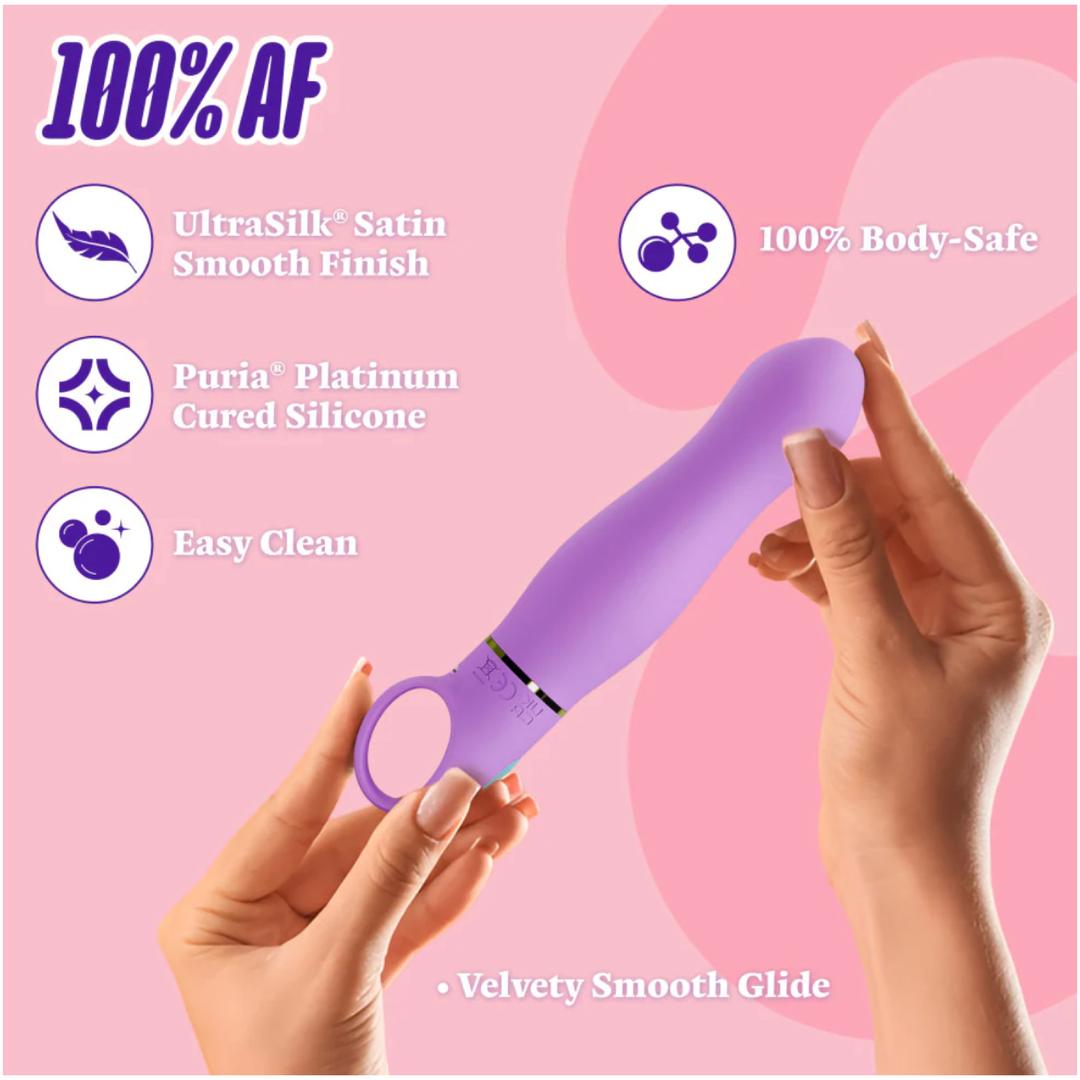 A person holds the Aria Rechargeable Vibe Exciting AF-Indigo by Blush Novelties on a pink background. Features: UltraSilk smooth finish, Puria platinum cured silicone, easy to clean, 100% body-safe, and velvety glide.