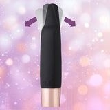 The Aspen 15-Function Flickering Tip Vibrator by Maia Toys is shown in black and rose gold, featuring a split, flexible tip with arrows highlighting its movement, set against a blurred purple and pink backdrop—a compact pleasure companion crafted to delight.