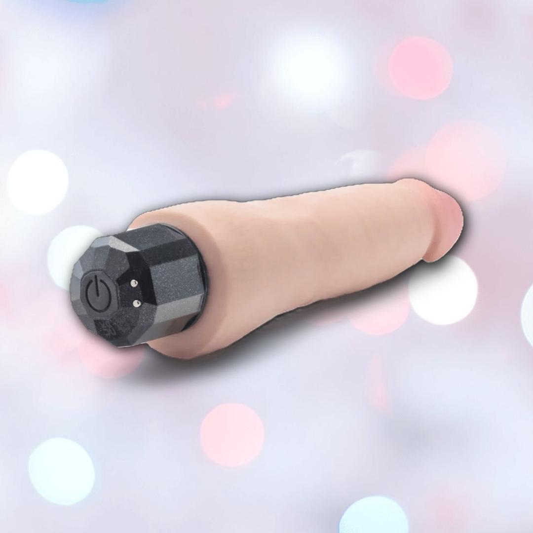 The Au Naturel Vanilla Ice Vibrating Dildo by Blush Novelties features a realistic texture, flesh-toned shaft, and black control base, displayed against a soft pastel bokeh background.