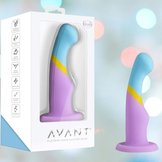 The Avant D14 Heart of Gold, a pastel artisanal toy in blue, yellow, and purple platinum-cured silicone, is shown inside and outside its white Avant box featuring icons on a softly blurred background. 1080