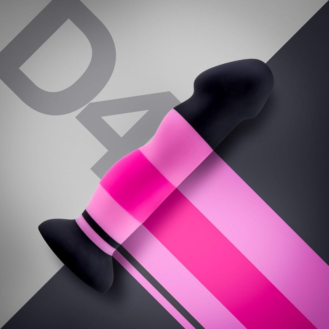 A product photo showcasing the Avant D4 7" Sexy in Pink Silicone Dildo with a deep suction cup base, positioned diagonally on a background divided into light gray and dark gray sections. The letters "DA" are partially visible in the upper left corner.