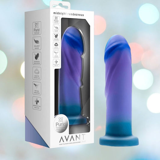 An Avant Midnight Rendezvous - Ocean Blue Realistic Dildo, made from platinum-cured silicone, is displayed next to its packaging. The box emphasizes attributes such as medical-grade materials, harness compatibility, and a suction cup base. The background includes a gentle bokeh effect. 1080