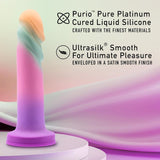 A pastel-hued Avant Sunrise Gaze - Sherbet Realistic Dildo by Avant is displayed against a wavy background. It boasts pure platinum-cured silicone and an ultrasilk smooth finish, highlighted by its practical suction cup base for enhanced pleasure.