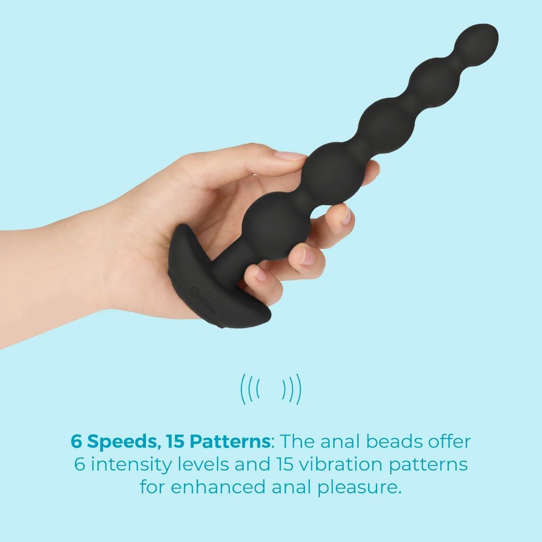 A hand holds the B-Vibe Cinco Beads XL Vibrating Anal Beads - Black by B-Vibe against a light blue background. Six speeds and 15 vibration patterns offer sensational anal play, perfect for exploring new sensations.