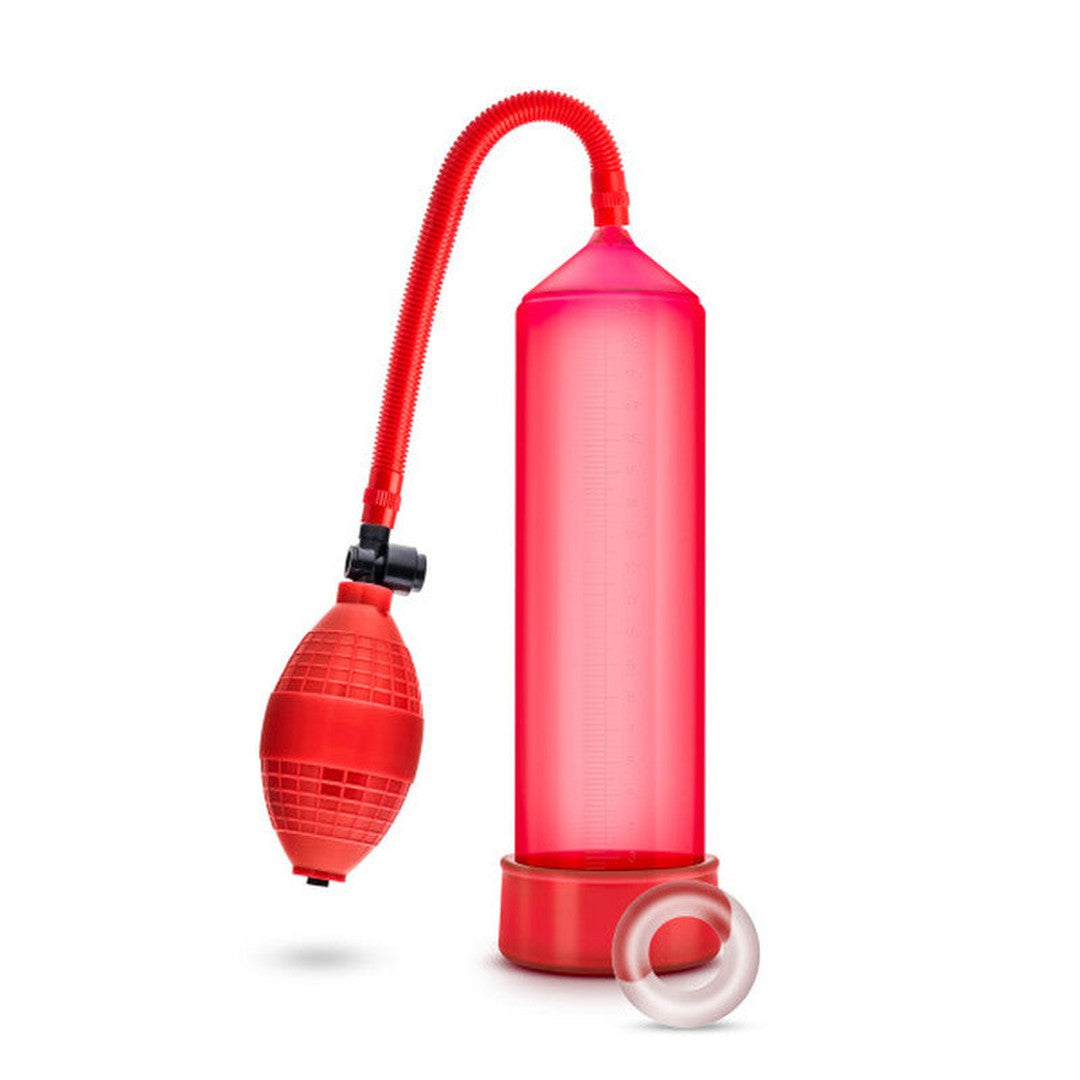 The Blush Novelties Performance VX101 Enhancement Pump in red boasts a transparent cylinder, a flexible tube, and a medical-grade ball pump with a squeeze bulb. It comes with a detachable Stay Hard Cock Ring, all displayed against a white background.