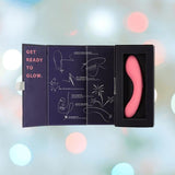 An open box reveals the bms The Mini Swan Wand Glow in the Dark - Pink on the right and "Get Ready to Glow" instructions on the left, all set against a dreamy pastel background with soft, glowing bokeh lights.