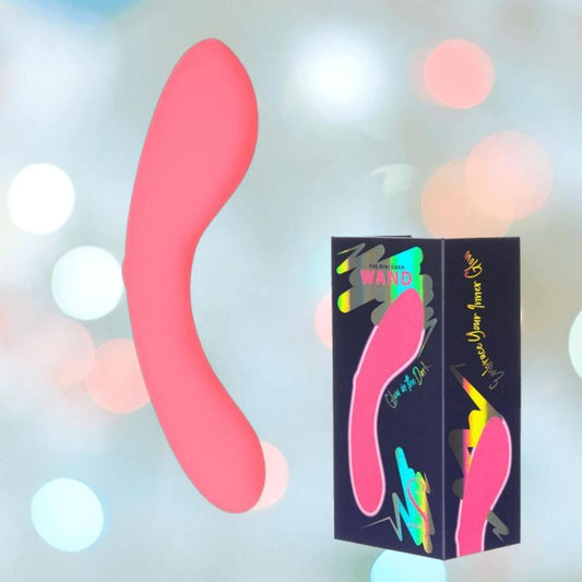 The BMS The Mini Swan Wand Glow in the Dark - Pink by bms is shown next to its black box, which displays the massager and colorful details. The soft background features blurred pastel bokeh lights. 1080