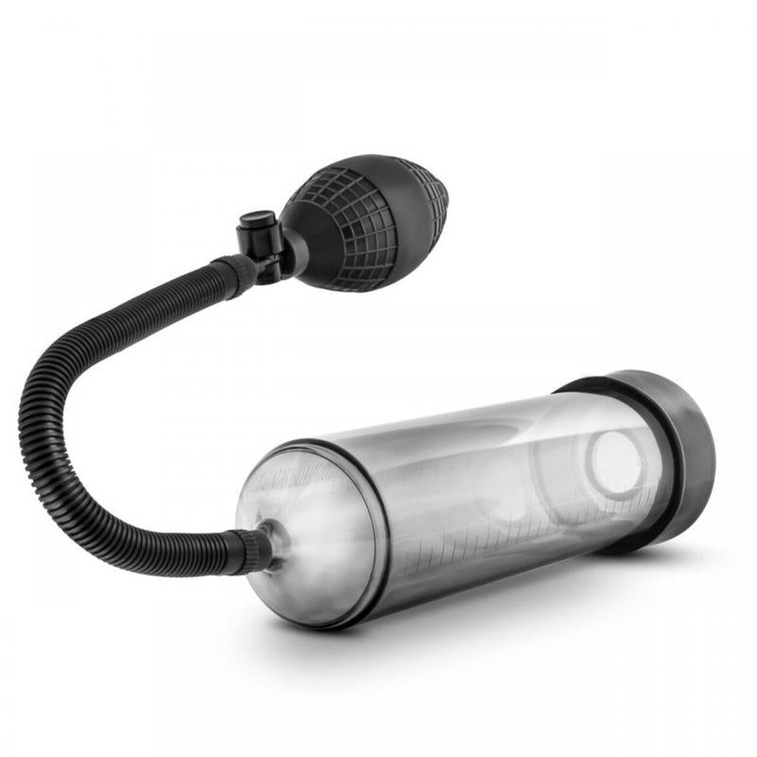 An image of the Performance VX101 Enhancement Penis Pump by Blush Novelties features a clear cylindrical chamber, a flexible tube, and a black hand-held bulb pump. The device is likely intended for medical or personal use. The entire assembly is set against a plain white background.