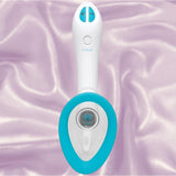 The Doc Johnson Bloom Rechargeable Intimate Body Pump - Blue features a white handheld design with blue accents, two buttons, and an oval-shaped opening. It rests on shiny lavender fabric.