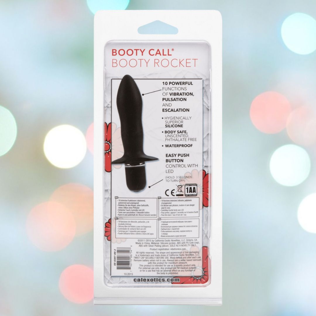 The packaging of the CalExotics Booty Call 'Booty Rocket' Vibrating Anal Stimulator emphasizes its waterproof silicone design and multiple vibration settings. The sleek black device is displayed against a blurred background featuring circular light patterns.