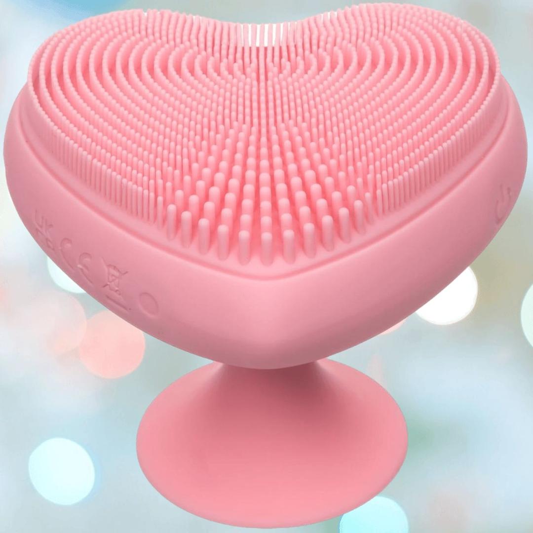 The CalExotics Posh Kiss Me Handheld Massager features a pink, heart-shaped design with textured pleasure nubbies and a suction base, shown against a soft, blurred background.