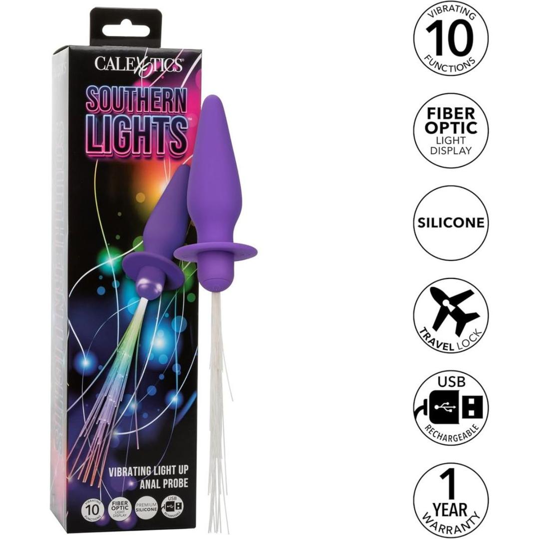 The CalExotics Southern Lights Vibrating Light Up Butt Plug is a purple silicone anal vibrator with fiber optic strands, 10 functions, USB rechargeability, travel lock, and a 1-year warranty—shown here next to its colorful box.