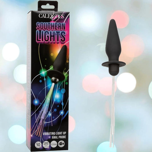 The CalExotics Southern Lights Vibrating Light Up Butt Plug Anal Vibrator Probe is displayed beside its colorful box, glowing with fiber optic strands as a black rechargeable silicone anal toy from CalExotics. 1080