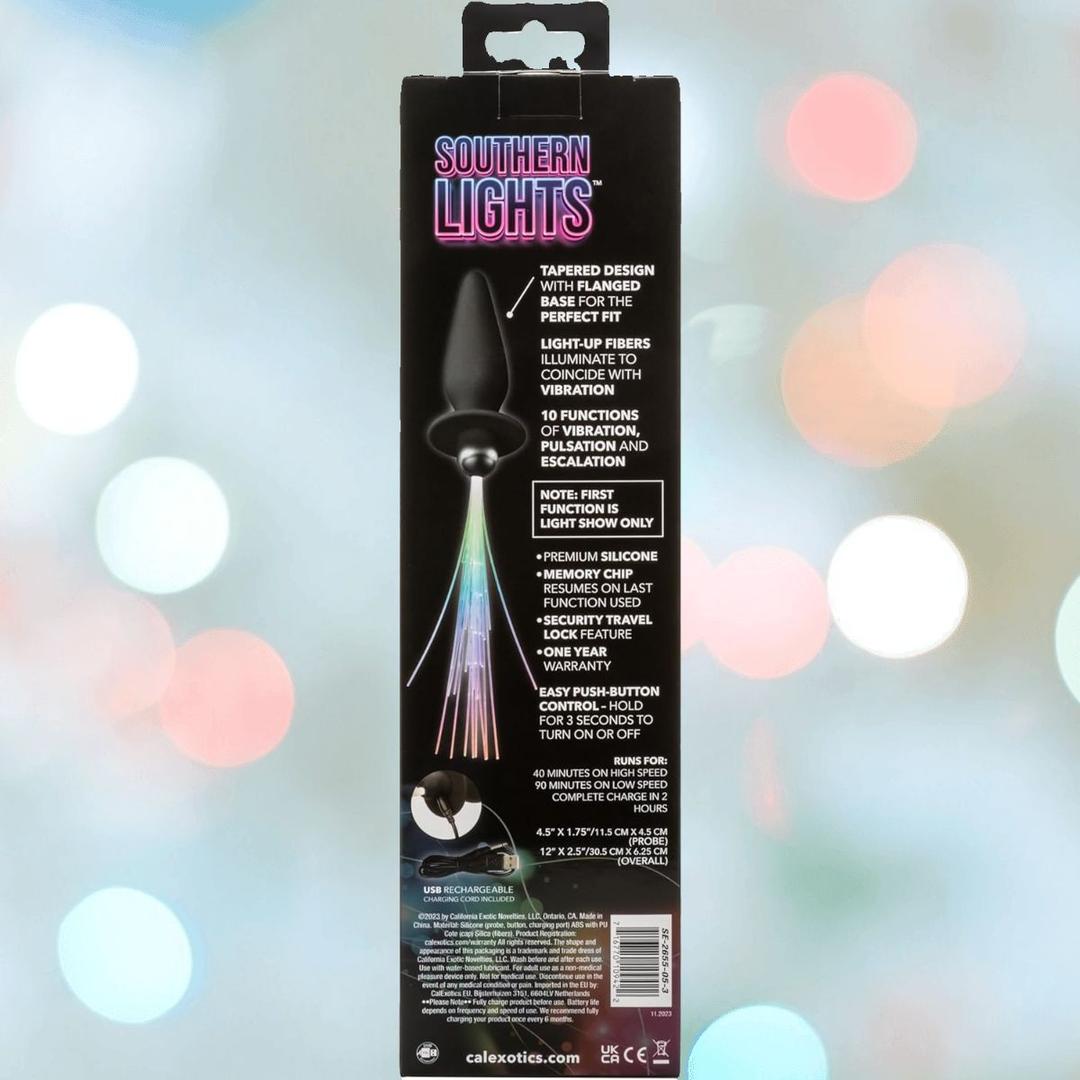 The CalExotics Southern Lights Vibrating Light Up Butt Plug Anal Vibrator Probe features a black design with colorful LED fiber optics at the base, remote control, USB charging, and multiple light functions, as shown on the packaging.