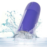 The CalExotics Connect Stroker with Vibration and Suction, a purple electronic device with two buttons, splashes into clear water, sending droplets and ripples across a white background.