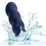 The CalExotics Cashmere Satin Swirl G, a black beaded silicone toy, is shown partially submerged in splashing water against a white background.