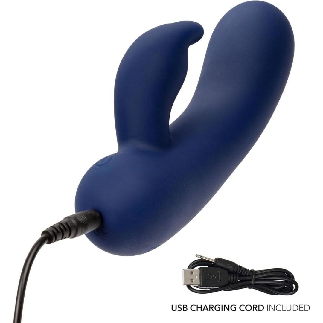 The CalExotics Cashmere Silk Bunny Rabbit Vibrator is a dark blue, curved silicone toy with a smaller extension, shown charging via USB. The included USB charging cord is separately displayed on a white background.