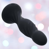 The CalExotics Deep Swirl Reverberating Probe is a black, spiral-textured waterproof vibrator made from body-safe silicone with rounded ends, shown against a soft backdrop of pink and white bokeh lights.