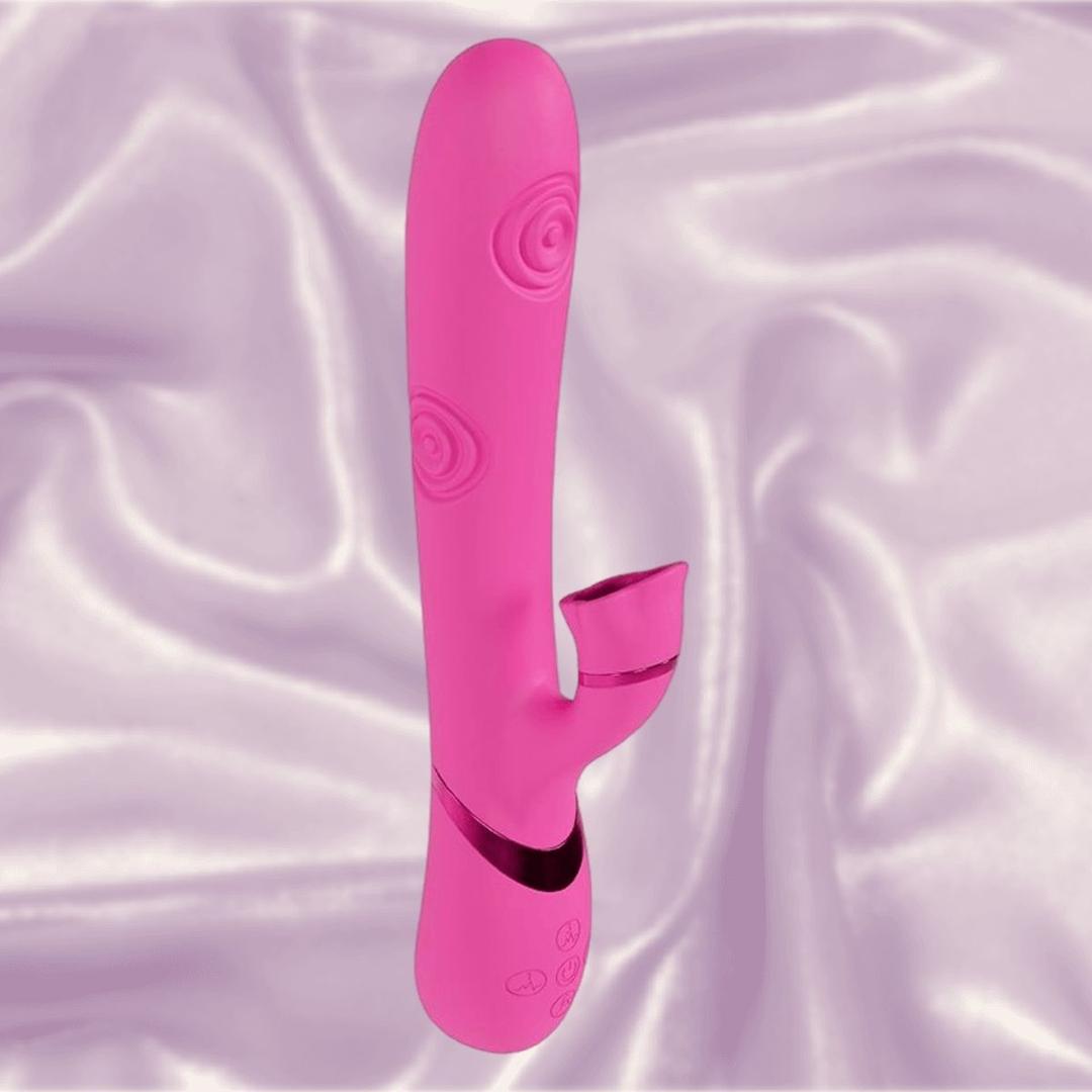 The Dolce Vive Fiore Rechargeable G-Spot Air Wave Vibrating and Tapping Clit by Shots America rests upright on silky, light lavender fabric, showcasing its pink silicone, curved shaft, spiral texture, and small external stimulator.