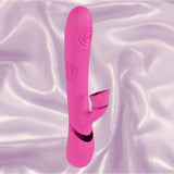 The Dolce Vive Fiore Rechargeable G-Spot Air Wave Vibrating and Tapping Clit by Shots America rests upright on silky, light lavender fabric, showcasing its pink silicone, curved shaft, spiral texture, and small external stimulator.
