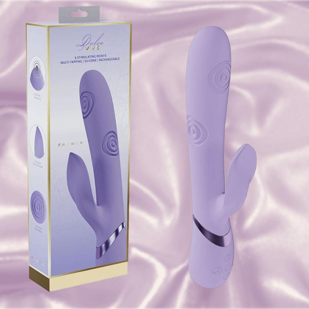 The Dolce Vive Fronda Rechargeable G-Spot Vibrating and Tapping Leaf Clit Stim by Shots America is a purple silicone vibe with a clitoral stimulator, smooth design, decorative lines, handle buttons, and comes in a box. Fully rechargeable.