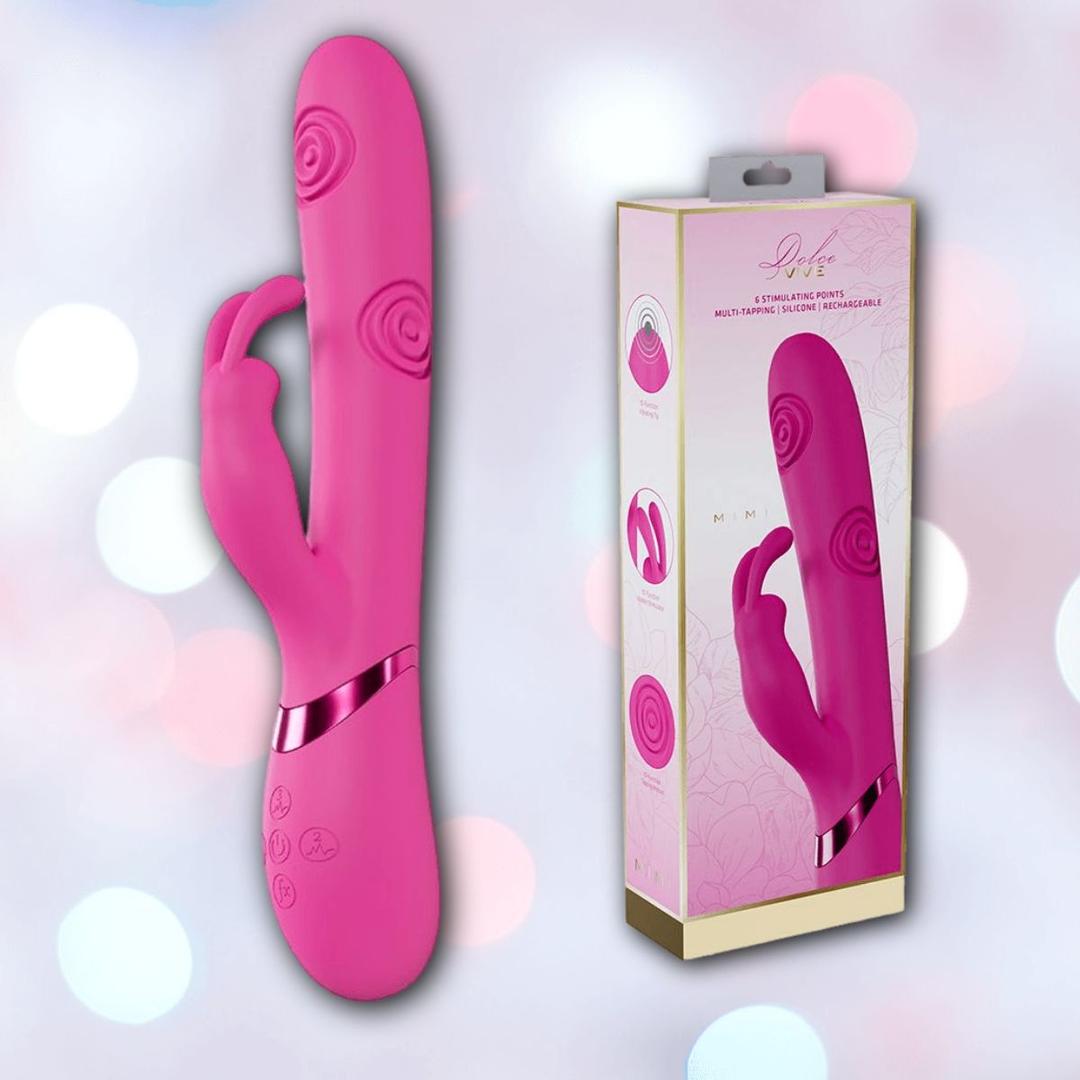 The Dolce Vive Mimi Rechargeable G-Spot Vibrating and Tapping Rabbit-Pink by Shots America, with a curved design and rabbit-shaped clitoral stimulator, is shown beside its floral-patterned packaging on a cream background.