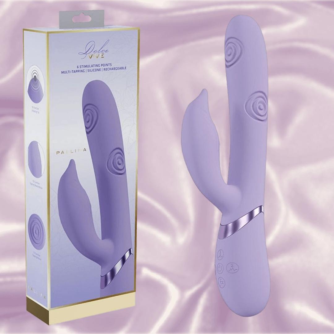 The Dolce Vive Pallina Rechargeable G-Spot Vibrating and Tapping Beads Clit by Shots America is displayed with its box, featuring a curved lavender design and textured tips, set on soft, light purple satin. The packaging showcases key features and product image.