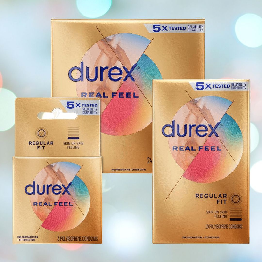 In the image, three Durex Avanti Bare Real-Feel condom packages are set against a blurred, colorful background. The gold packaging emphasizes "5X Tested," "Regular Fit," and assures a "Skin on Skin Feeling." These condoms are latex-free and made from polyisoprene for enhanced sensation.