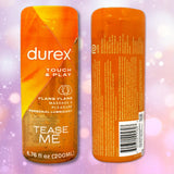 Two orange bottles of Durex Touch & Play Personal Lubricant with Ylang Ylang are displayed—one showing the front label and one showing the back label—against a vibrant purple bokeh background.