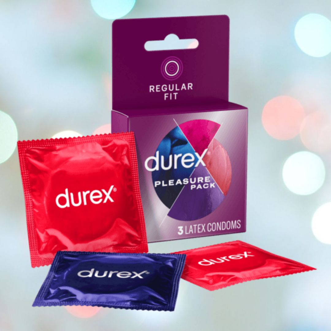 Image of a Durex Pleasure Pack Assorted Condoms box featuring three latex condoms in colorful red and blue wrappers designed for pleasure enhancement. The softly blurred background with circular light effects adds a touch of allure.