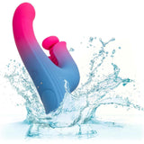 The CalExotics Elation Thrusting Dual Stimulator Rabbit Vibrator, in blue and pink silicone, plunges into clear water against a white background, showcasing its waterproof design with visible droplets.