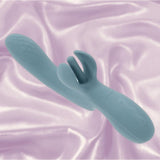 The Evolved Take Your Flick by Evolved Novelties, a teal silicone waterproof vibrator with textured detail and control buttons, rests on shimmery pink fabric, offering customizable pleasure.