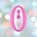 The Femme Funn Ossia Wearable Bullet Vibrator - Pink by Femme Funn is a handheld device with a pink outer casing and a white center featuring a lightning bolt symbol and a power button. It offers 10 vibration modes and is showcased against a backdrop of softly blurred, multicolored lights creating a bokeh effect.