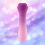 The FemmeFunn Anniversary Ultra Bullet Orchid by Femme Funn is centered against a soft, blurred background of pink, purple, and blue lights, showcasing this travel-friendly vibrator’s sleek silicone design.
