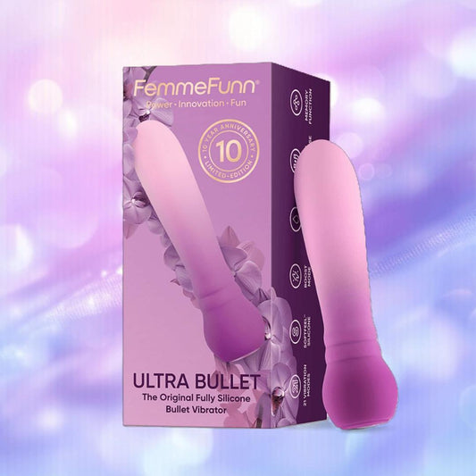 The Femme Funn Anniversary Ultra Bullet Orchid, a purple and pink silicone vibrator, stands by its matching box against a pastel background with soft bokeh, highlighting its travel-friendly design. 1080