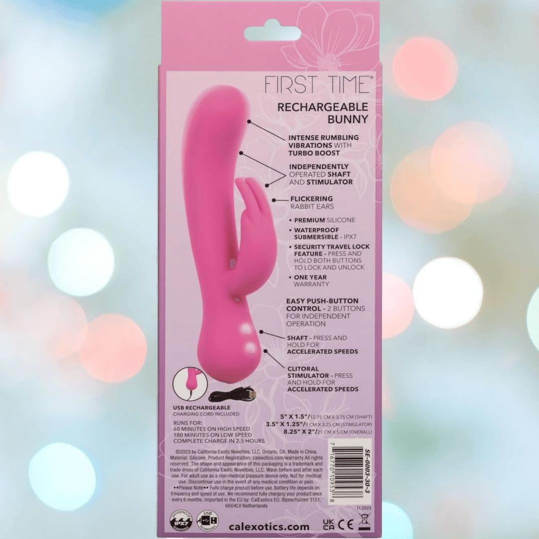 The CalExotics First Time Rechargeable Bunny with Turbo Boost Accelerated Speeds is shown in its packaging, with intense vibration features highlighted on the back and a playful backdrop of softly blurred pastel lights.
